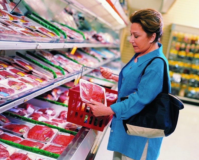 A woman shops for meat at a grocery store