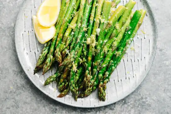 plate with asparagus and lemon wedges