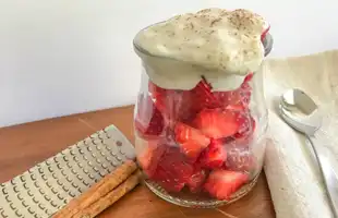 glass jar of slice berries with banana cream on top