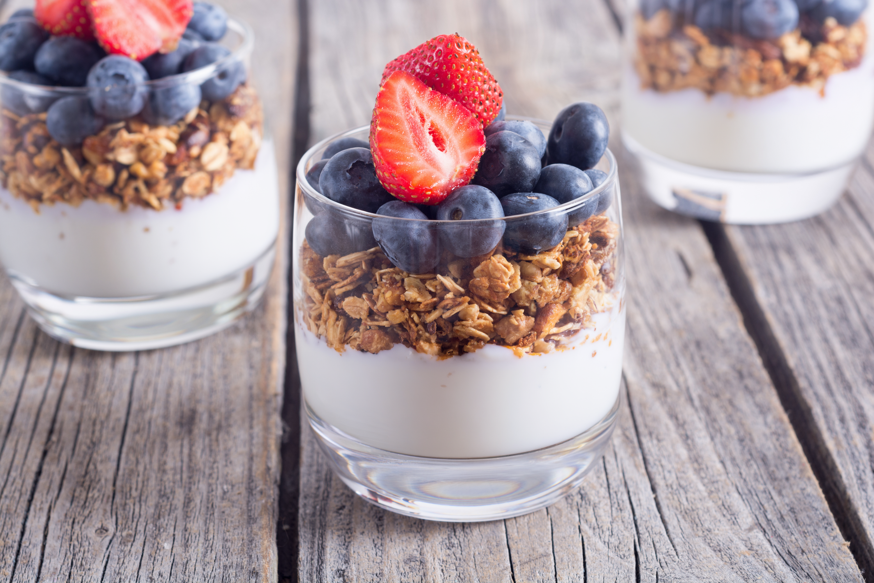 3 clear bowls with berry parfait in them