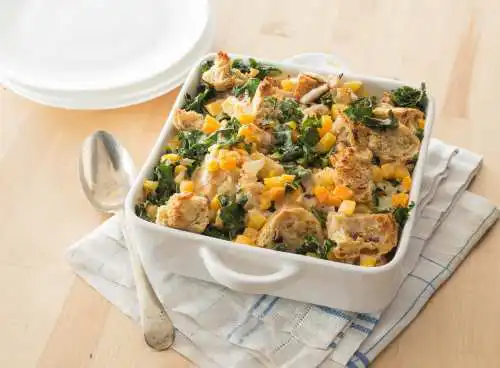 bowl of bread pudding with squash and kale