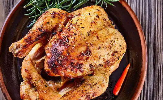 whole roast chicken on a red plate