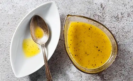 container of dressing with a spoon in a spoon rest
