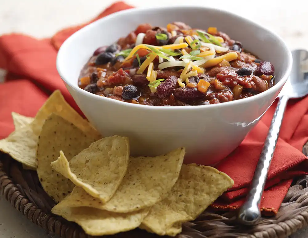 bowl of chili with chips on the side