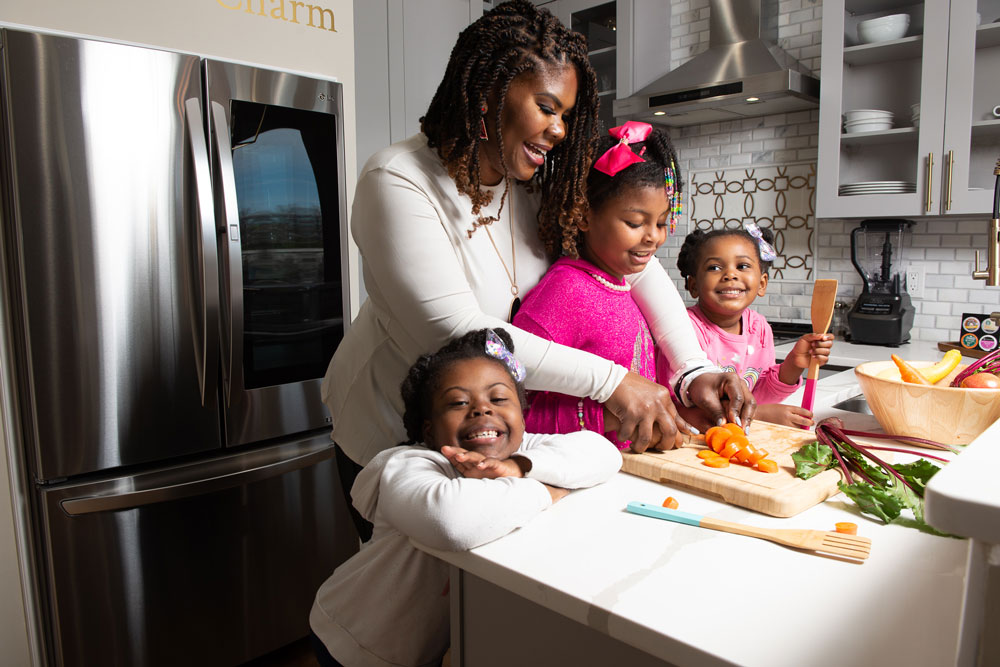 image of Dr. Cotwright cooking with her three daughters in the kitchen.