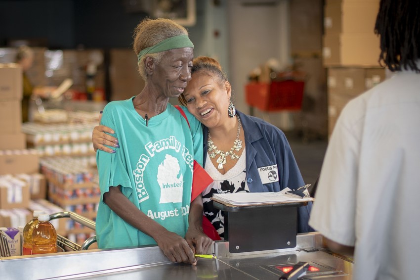 women hugging at the checkout