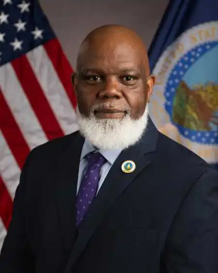 Willie C. Taylor in front of the US flag and the USDA flag