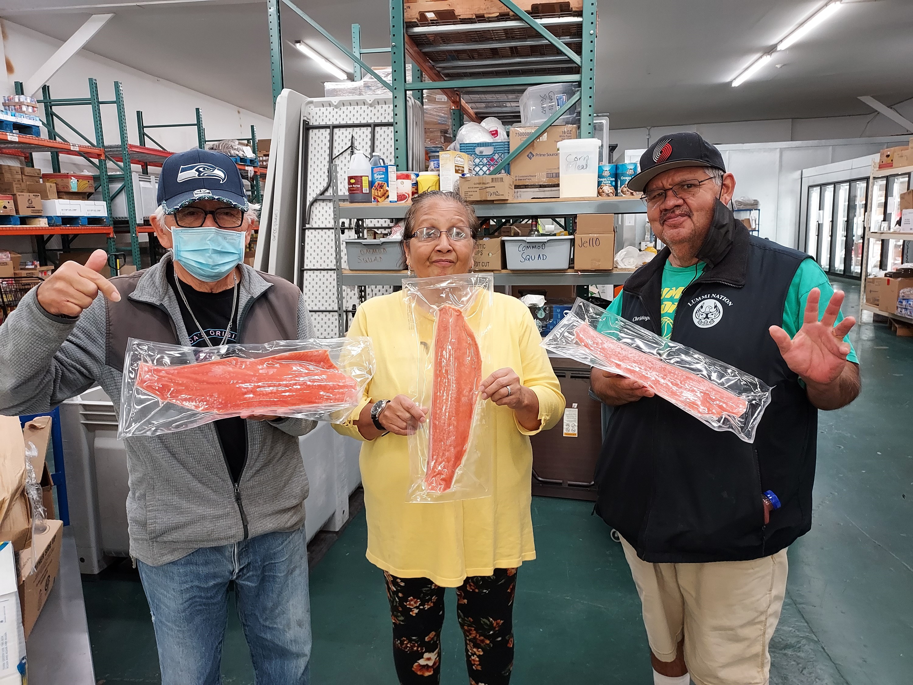 3 staff holding frozen fish in an FDPIR store