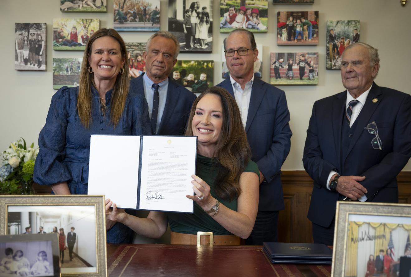 Secretary Rollins holding her signed waiver surrounded by other Governors and HHS secretary.