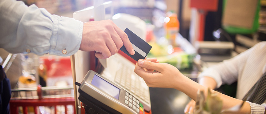 image of a grocery store retailer accepting a credit card