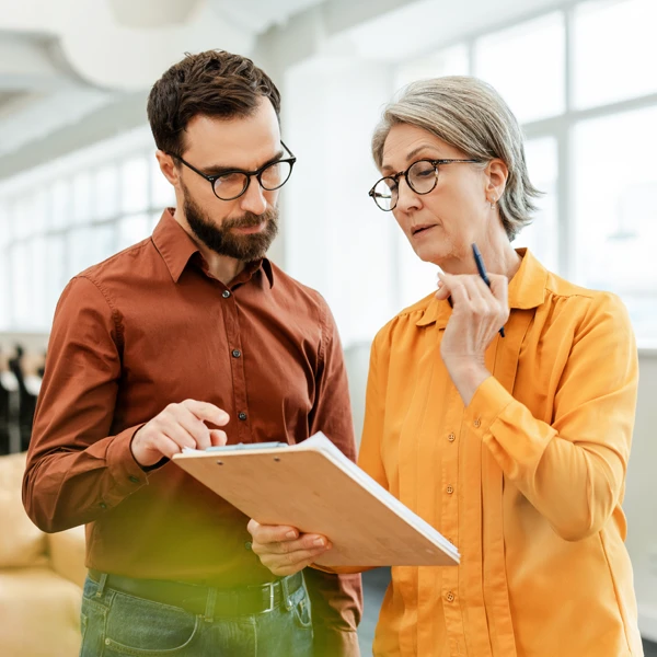 man and woman looking a a clipboard together