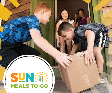 SUN Meals To-Go logo in bottom left of image of two boys picking up a cardboard box to take inside