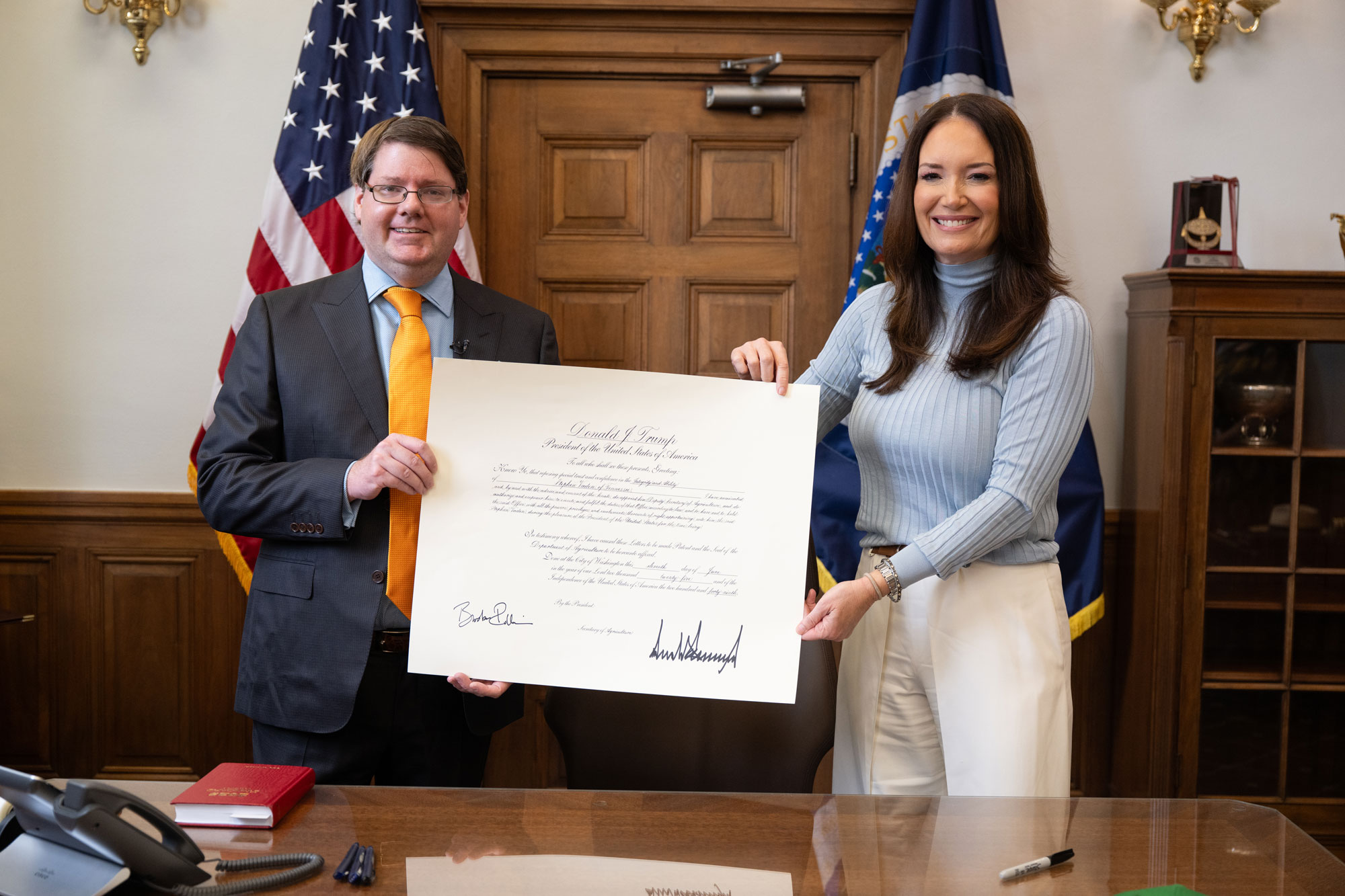 Secretary Rollins and Deputy Secretary Vaden holding a signed copy of a bill.