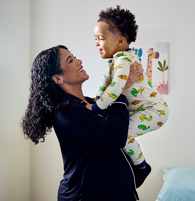 a woman holding a small boy up in the air