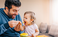 man feeding a toddler