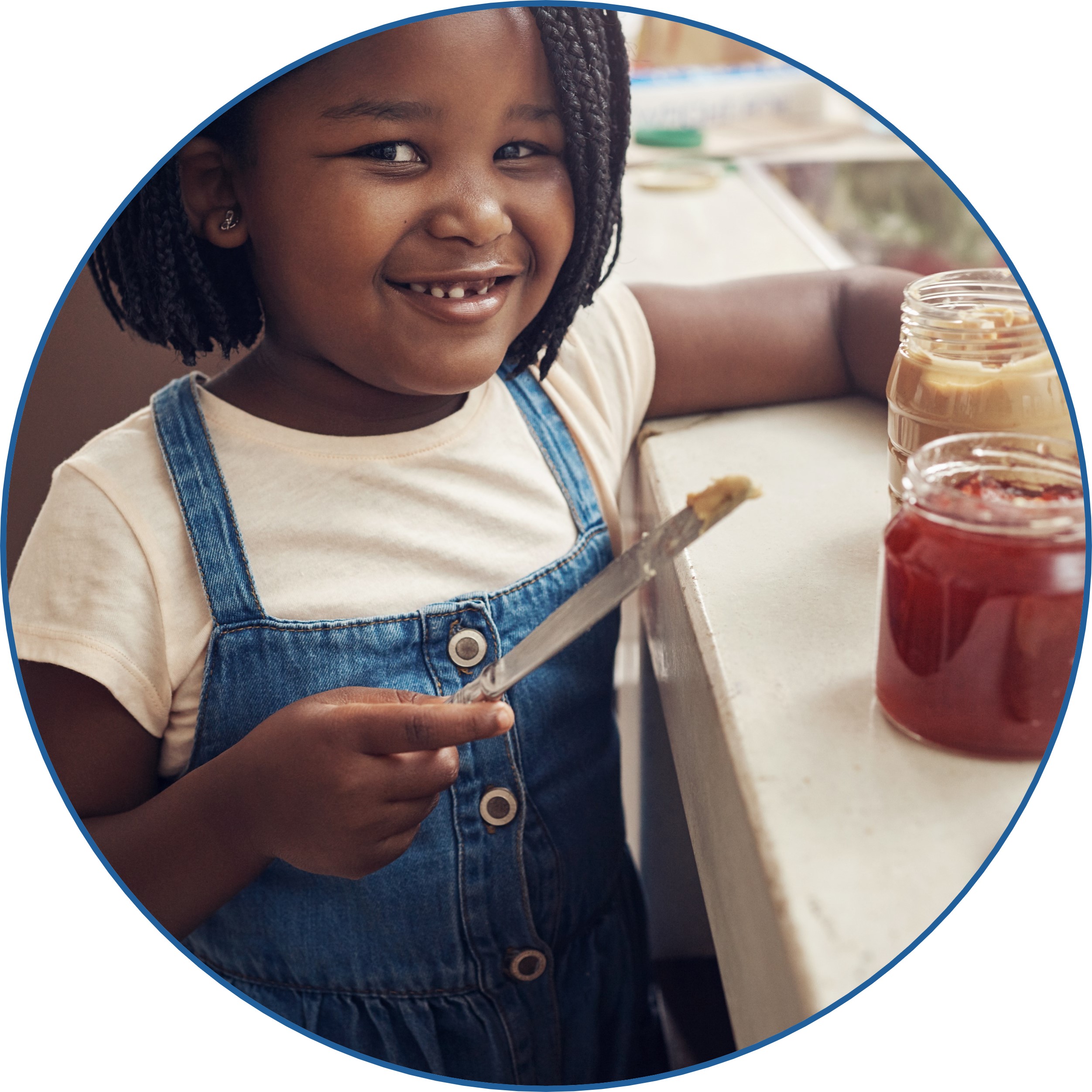 A girl making a sandwich with peanut butter.