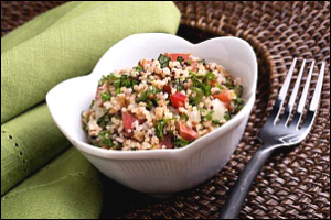 bowl of grains with tomatoes, cucumbers and other ingredients