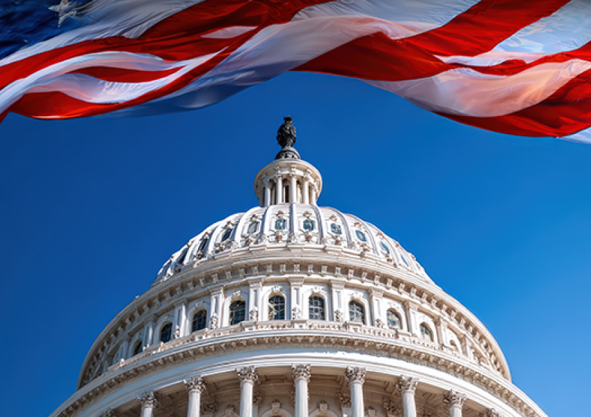 the top of the Congress building centered with a giant American flag waving above it