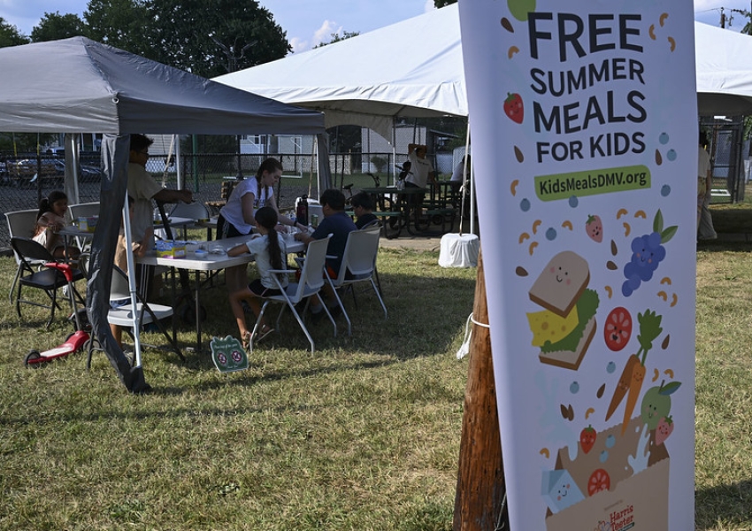 poster advertising Free Summer Meals for Kids with tents in the background with kids eating at tables