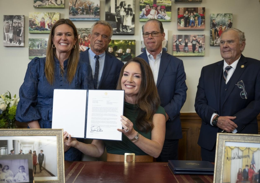 Secretary Rollins holding her signed waiver surrounded by other Governors and HHS secretary.
