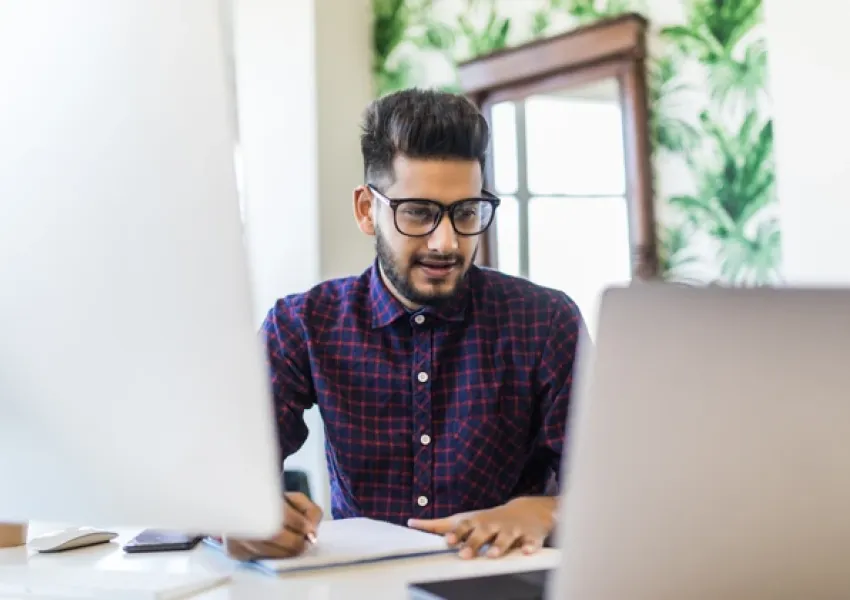 man at a desk typing on a computer