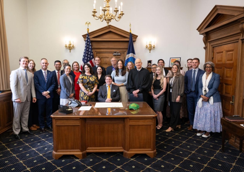 Vaden sitting at a desk surrounded by other USDA staff at his swearing in.