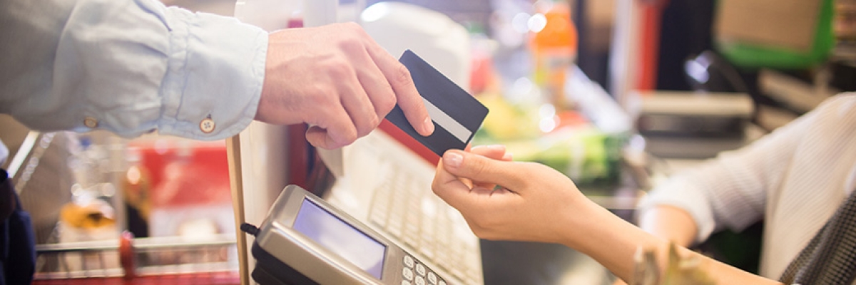 image of a grocery store retailer accepting a credit card