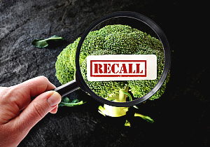 recall image over broccoli with magnifying glass.