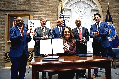Secretary Rollins displaying signed waiver with other administration officials behind her