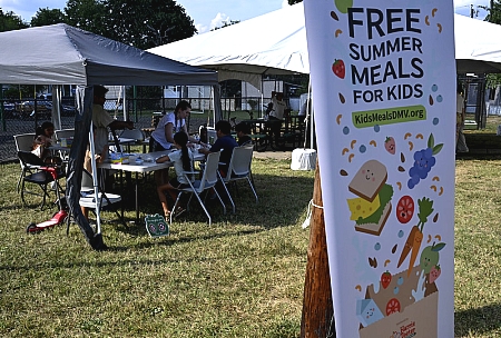 poster advertising Free Summer Meals for Kids with tents in the background with kids eating at tables