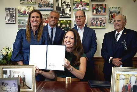 Secretary Rollins holding her signed waiver surrounded by other Governors and HHS secretary.