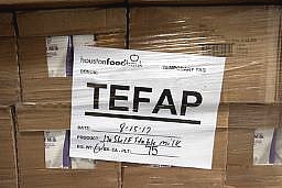 a pallet of shelf stable milk boxes with a TEFAP sign on it