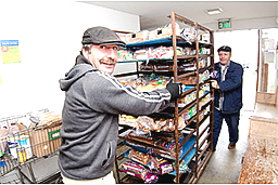 two men in page boy hats wheeling a cart of bread